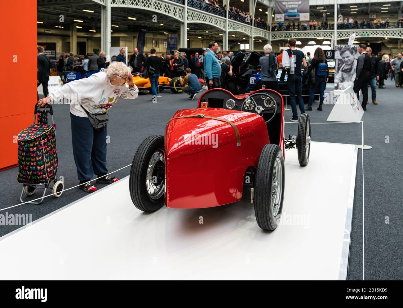 22 Feb 2020 - Londra, Regno Unito. Vecchia donna curiosamente controllo sul restaurato 1929 Austin Ulster modello al Classic Car Show. Foto Stock