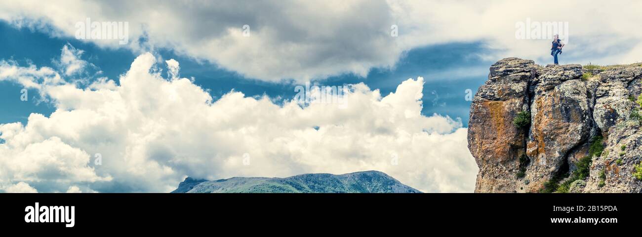 Turistica sulla montagna Demerdji in Crimea, Russia. Donna viaggiatore in cima a una montagna sulle nuvole sfondo. Banner orizzontale del concetto di viaggio per Foto Stock