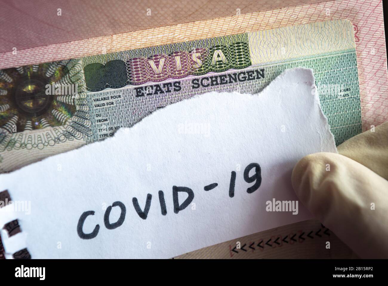 Concetto di coronavirus. Nota COVID-19 coronavirus e visto Schengen in passaporto. Controllo delle frontiere e quarantena dei turisti affetti da coronavirus. Nov Foto Stock