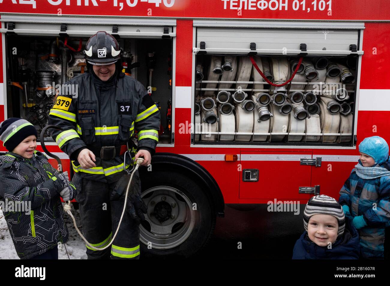 Mosca, Russia. 23rd di febbraio, 2020 Emergency officer mostra ai bambini i dispositivi di un camion antincendio durante una dimostrazione di attrezzature antincendio in onore del 30 anniversario di MCHS a VDNKH a Mosca, Russia Foto Stock