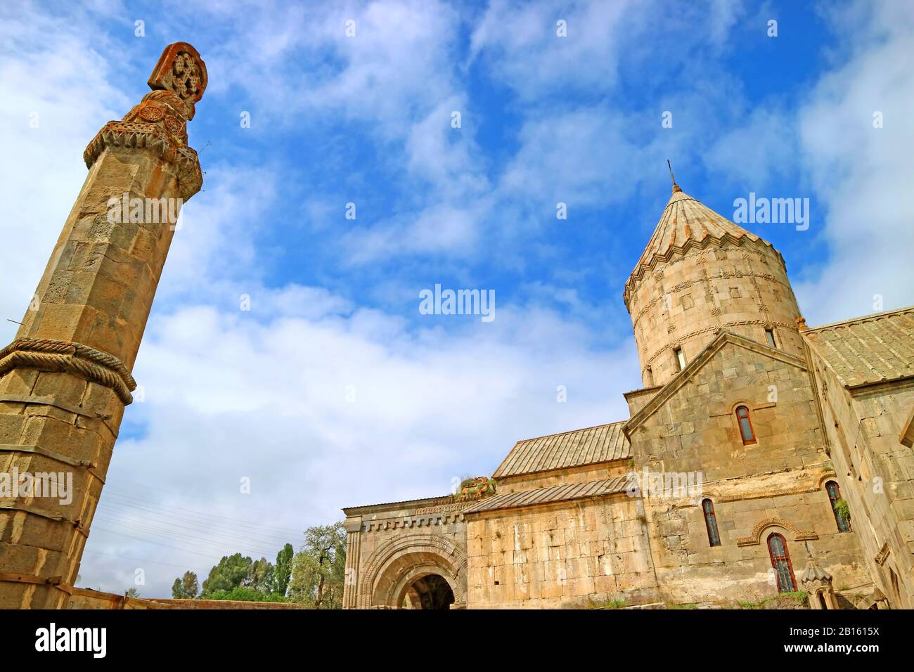 Pilastro Seismografico Di Gavazan Con Chiesa Di San Paolo E Pietro Contro Il Cielo Nuvoloso Blu, Complesso Del Monastero Di Tatev, Armenia Foto Stock