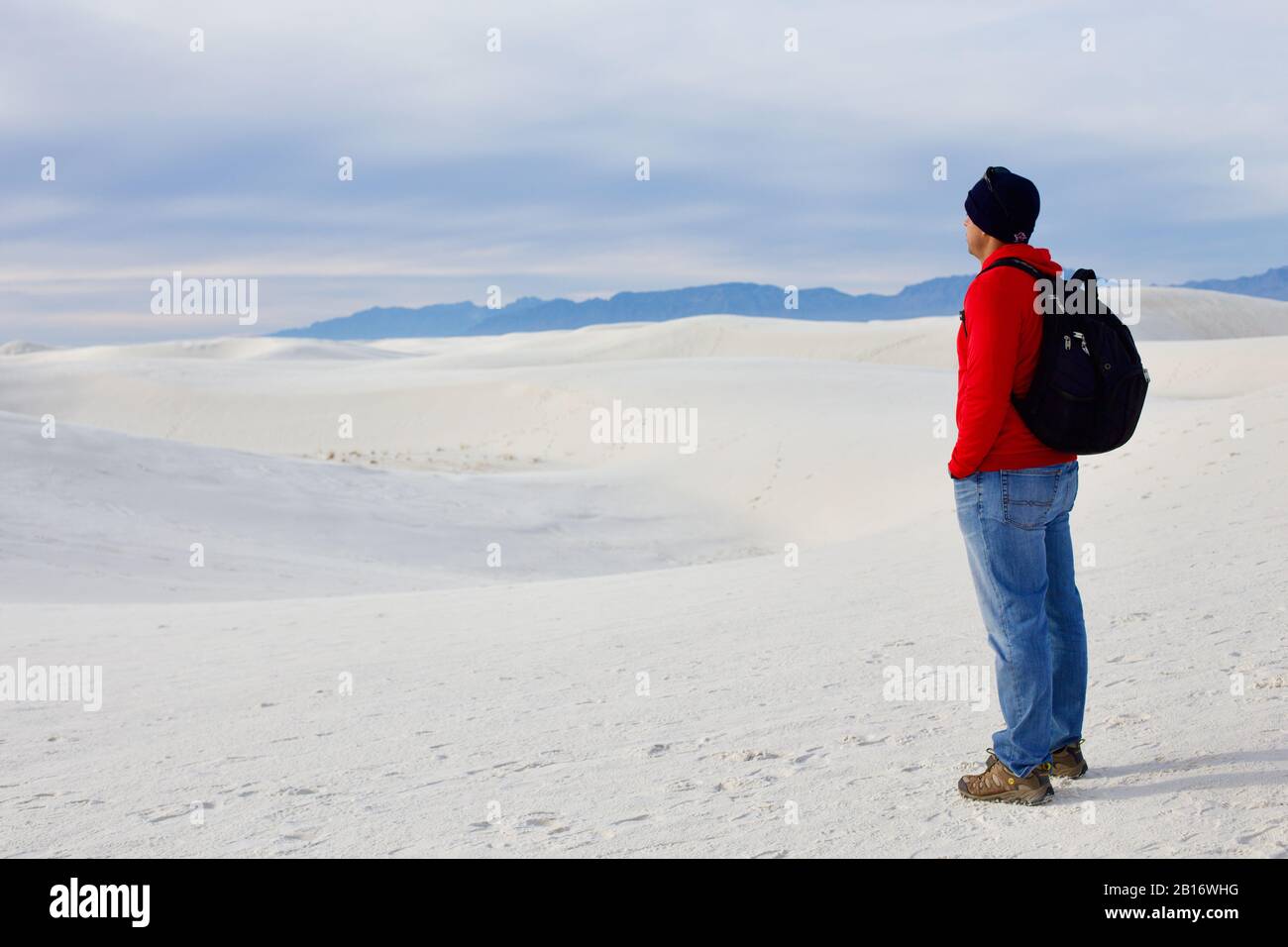 Uomo che stellato nella distanza in sabbia bianca o neve Foto Stock