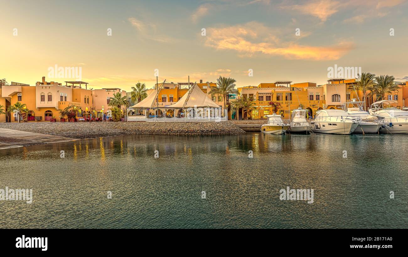 Ristoranti e yacht a motore con spazio per la copia all'ancora al tramonto con cielo arancione al New Marina, el Gouna, Egitto, 17 gennaio 2020 Foto Stock