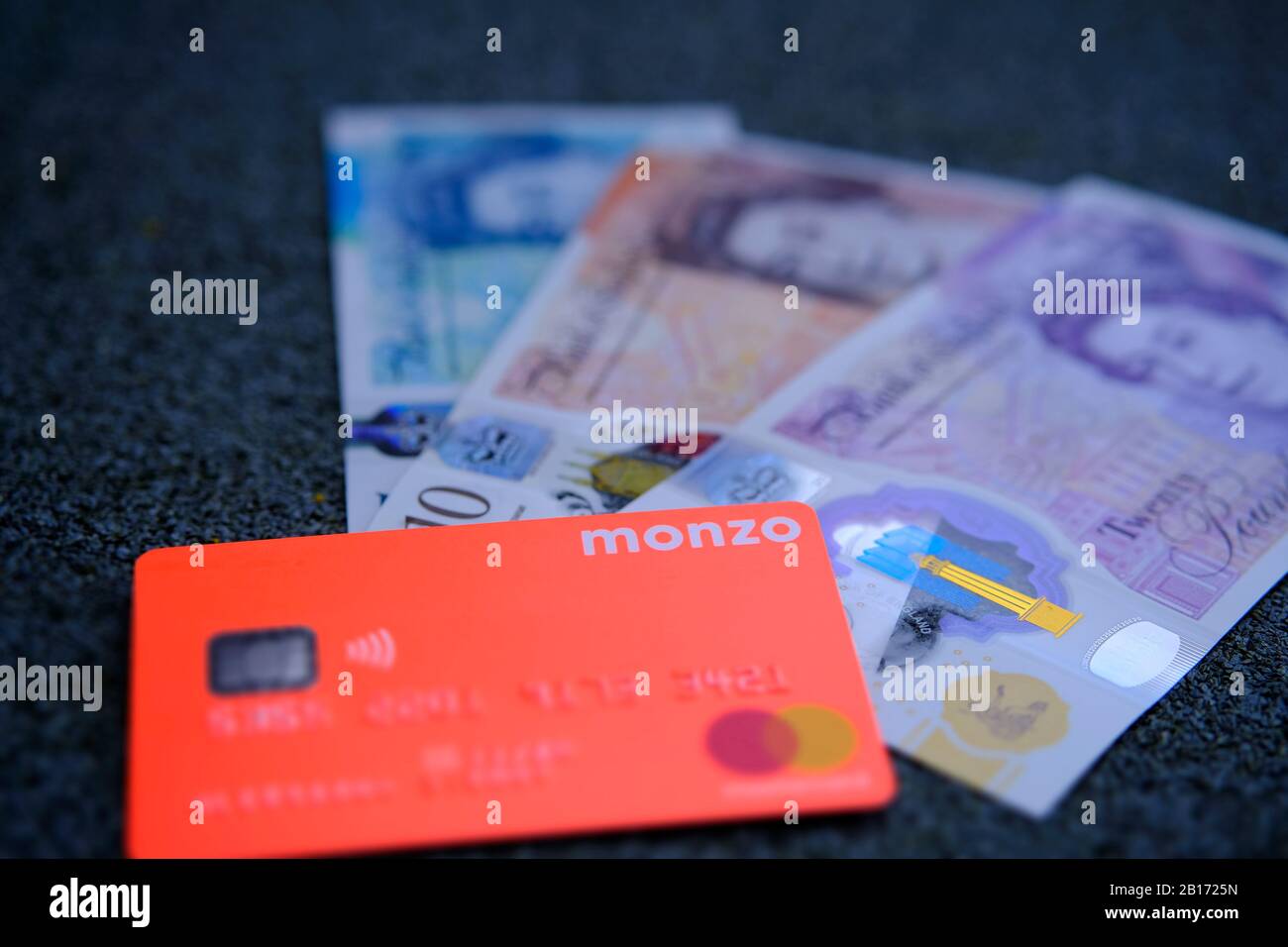 Carta bancaria Monzo con nuove banconote in polimero britannico. Foto Stock