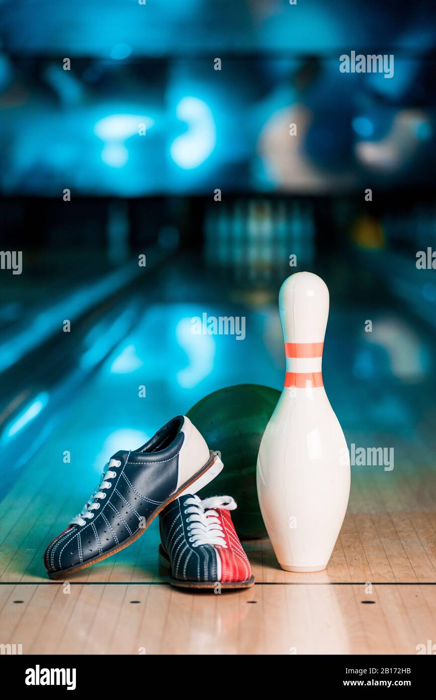 focus selettivo di scarpe da bowling, palla e skittle sulla pista da bowling Foto Stock