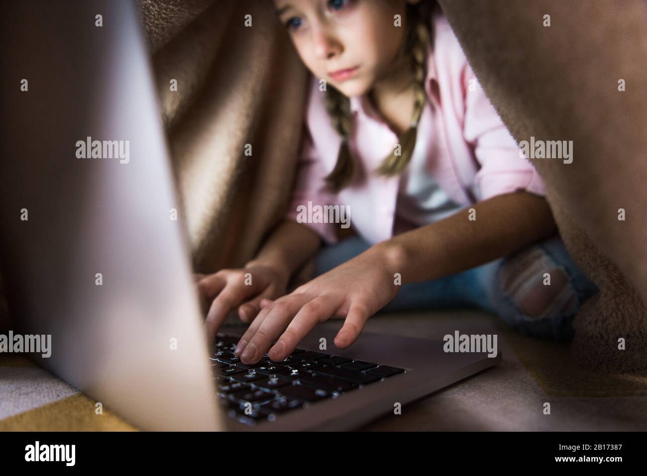 fuoco selettivo del capretto frustrato coperto nella battitura a macchina coperta sulla tastiera del laptop, concetto di cyberbullismo Foto Stock