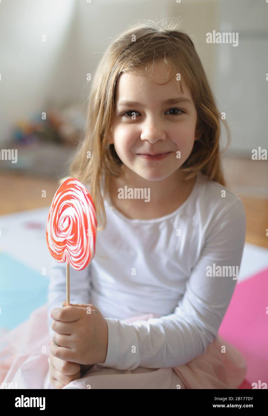 La bambina gioca e mangia lillypop. Foto Stock
