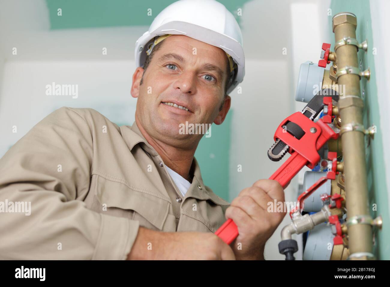 un lavoratore sorridente che fissa tubi Foto Stock