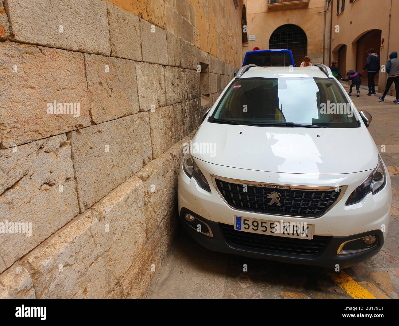 Parcheggio auto vicino a zu un muro nella città vecchia di Alcúdia, Spagna, Isole Baleari, Maiorca, Alcudia Foto Stock