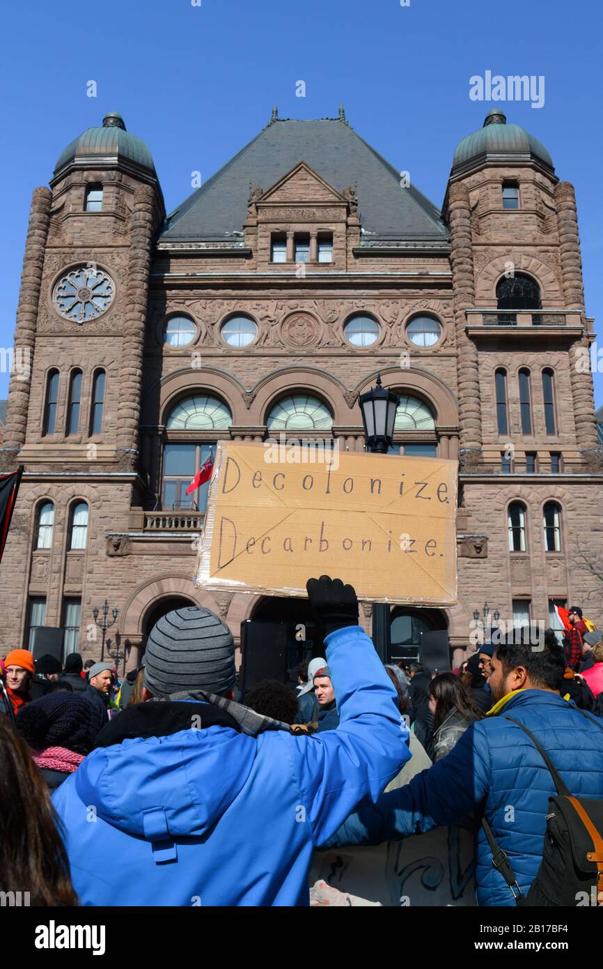 Un protestante chiede la decolonizzazione al di fuori dell'Ontario legislative Building durante la chiusura Canada protesta solidarietà con Il Wet'suwet'en. Foto Stock