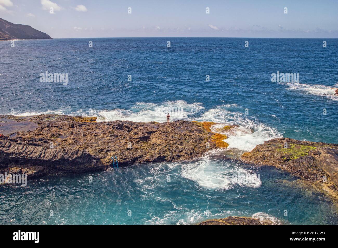 Spagna, la Gomera, Hermigua, uomo in piedi sulla scogliera vicino alla piscina di acqua di mare Foto Stock