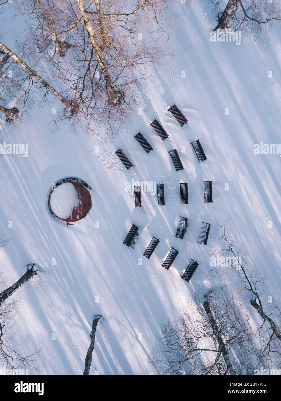 Panchine vuote nel parco innevato, vista sui droni Foto Stock