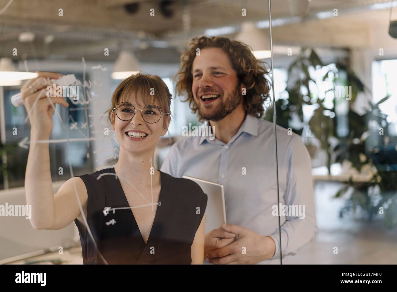 Buon uomo d'affari e donna d'affari che lavora su un progetto in ufficio Foto Stock