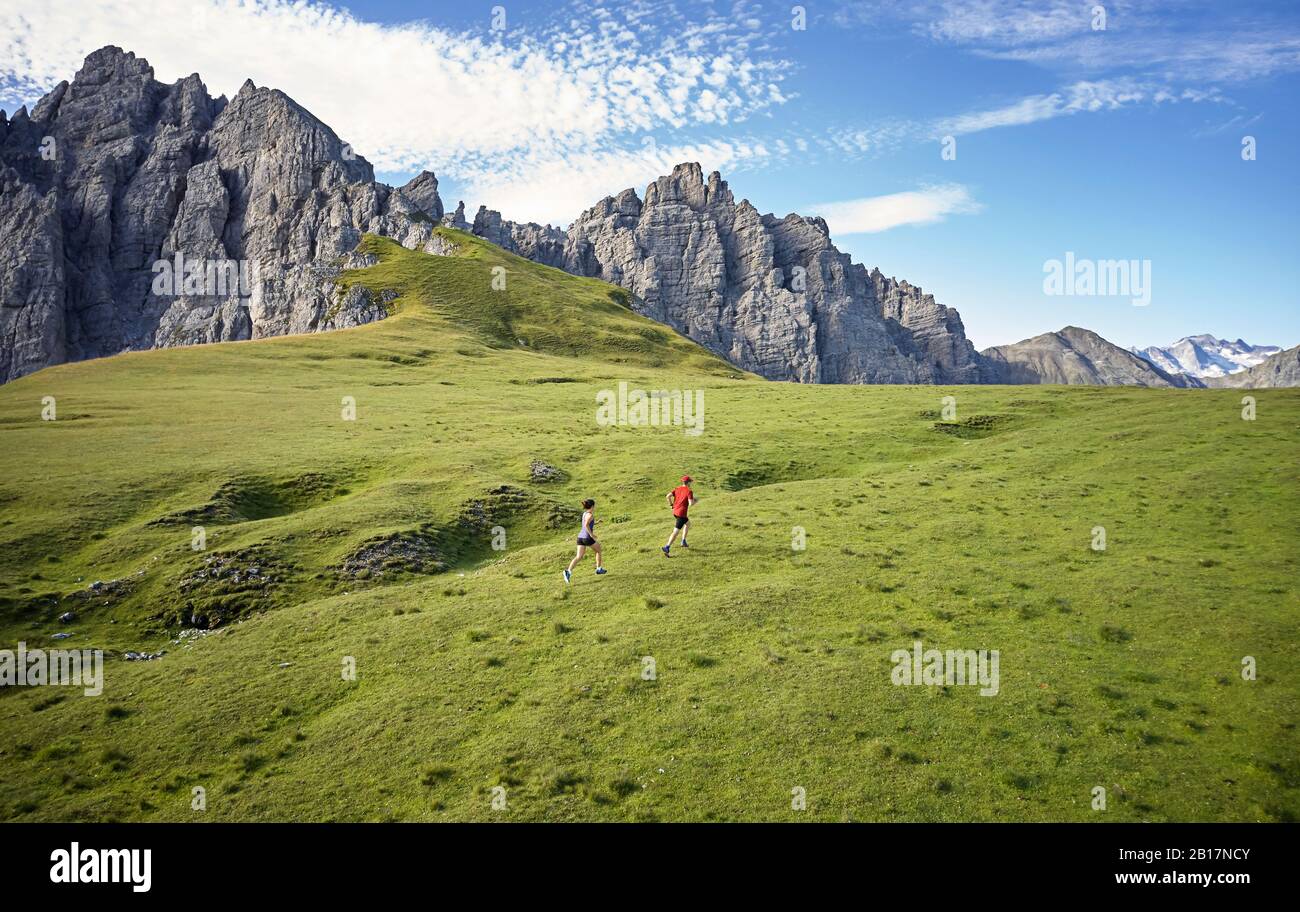Uomo e donna che corrono in montagna Foto Stock