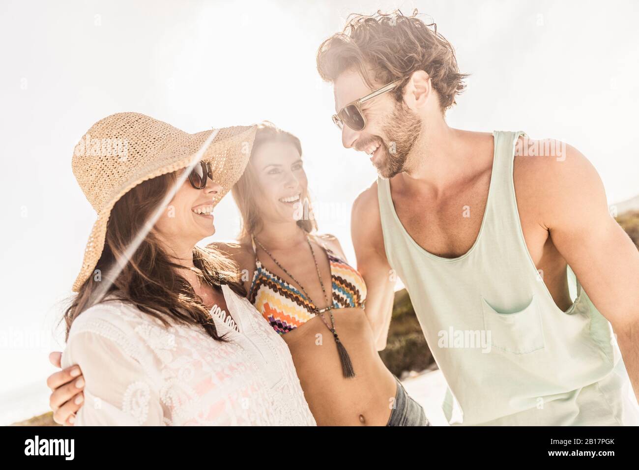 Due donne felici e un uomo che socializza all'aperto in estate Foto Stock