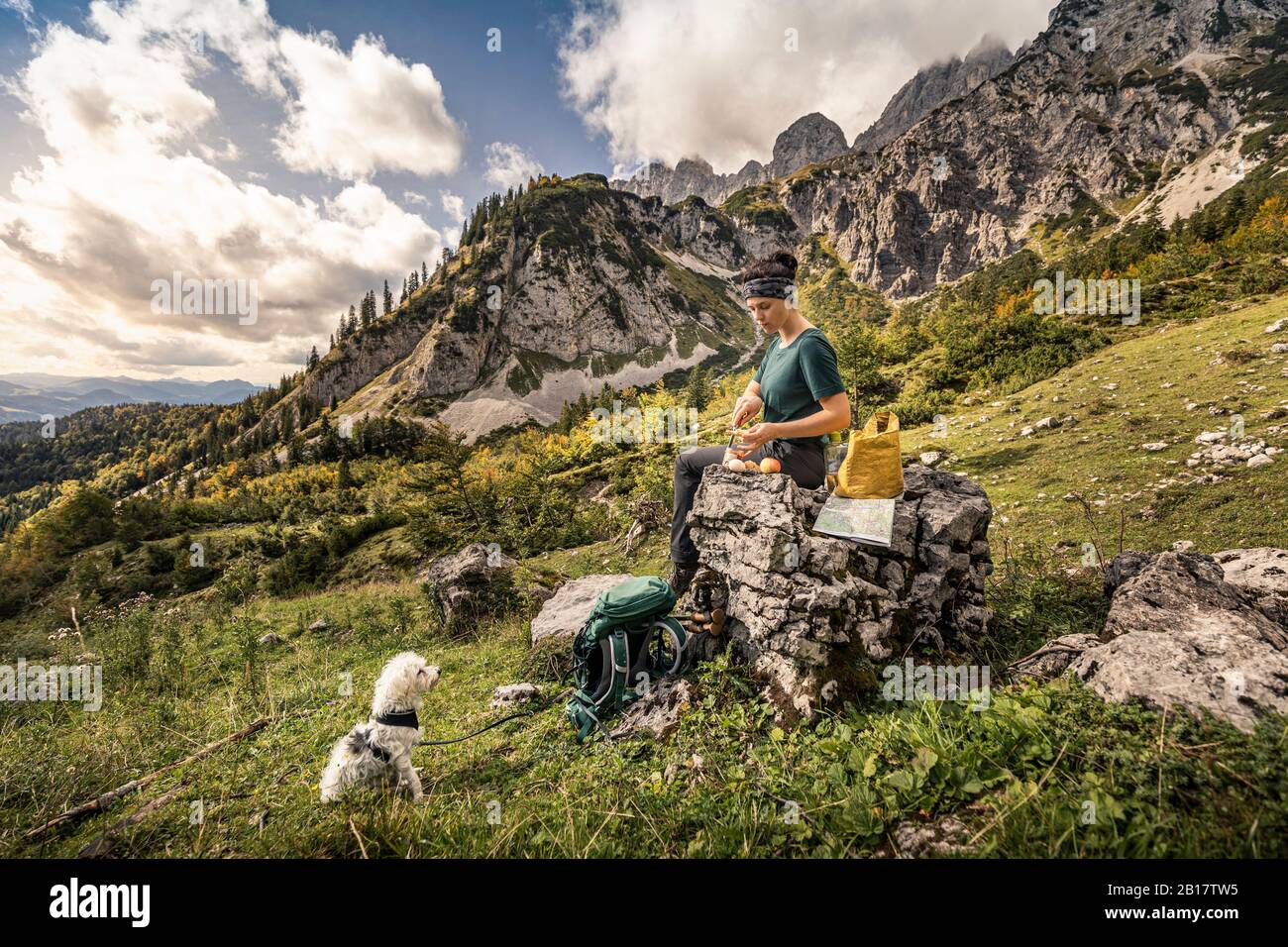 Donna con cane in un viaggio a piedi a Wilder Kaiser dopo una pausa, Kaiser montagne, Tirolo, Austria Foto Stock