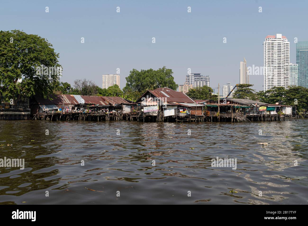 Capanne sul fiume Chao Phraya, alti edifici sullo sfondo, Bangkok, Thailandia Foto Stock