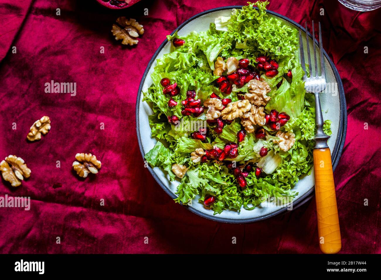 Ciotola di insalata verde con noci e semi di melograno Foto Stock