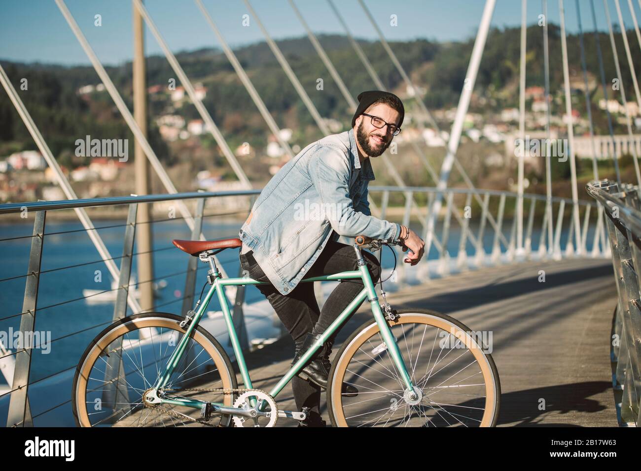 Giovane uomo che si trova in città con la sua bici fixie Foto Stock