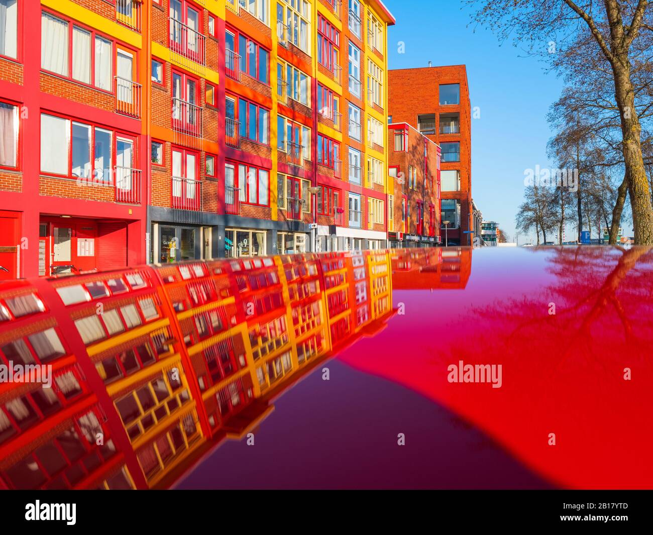 Paesi Bassi, Friesland, Groningen, Jachthaven Oosterhaven, edifici colorati riflessi in superficie rossa Foto Stock