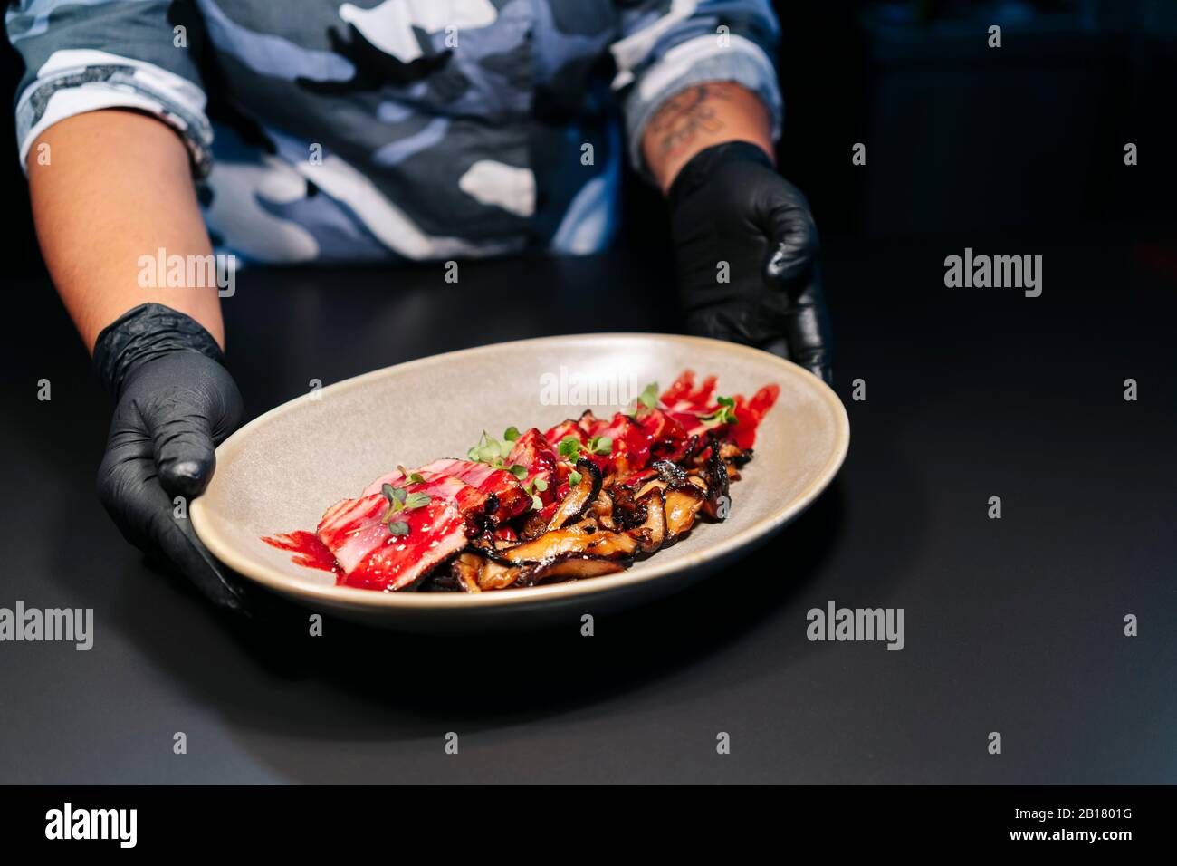 Chef che mostra piatti preparati al tavolo nella cucina del ristorante Foto Stock