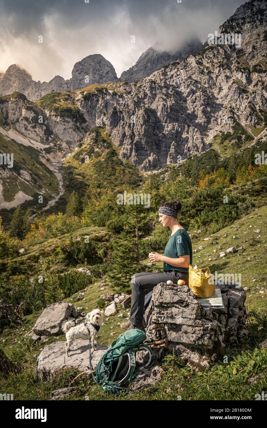 Donna con cane in un viaggio a piedi a Wilder Kaiser dopo una pausa, Kaiser montagne, Tirolo, Austria Foto Stock