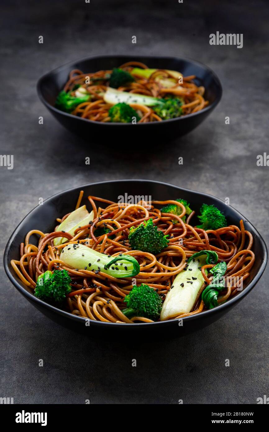 Due ciotole di pasta di soba con choi di pak e broccoli, salsa di soia e sesamo nero Foto Stock