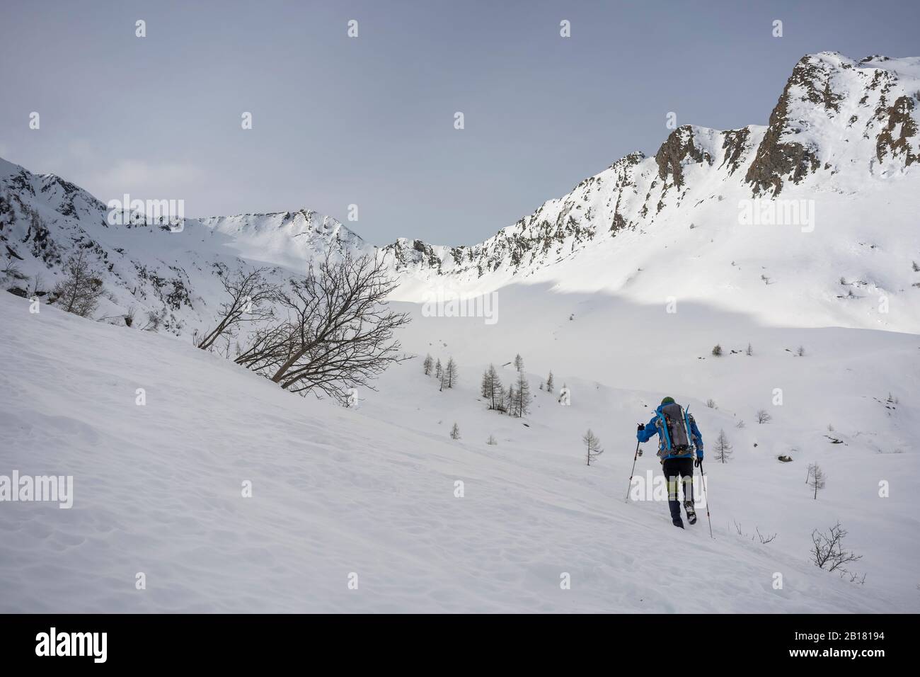 Uomo in escursione in montagna innevata, Lombardia, Valtellina, Italia Foto Stock