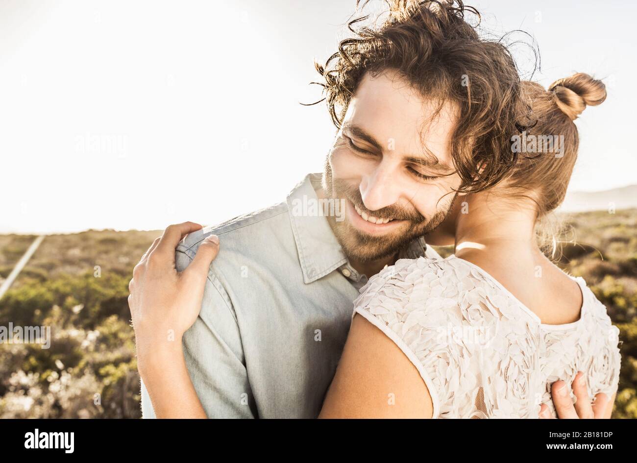Felice giovane coppia abbracciare alla costa in estate Foto Stock