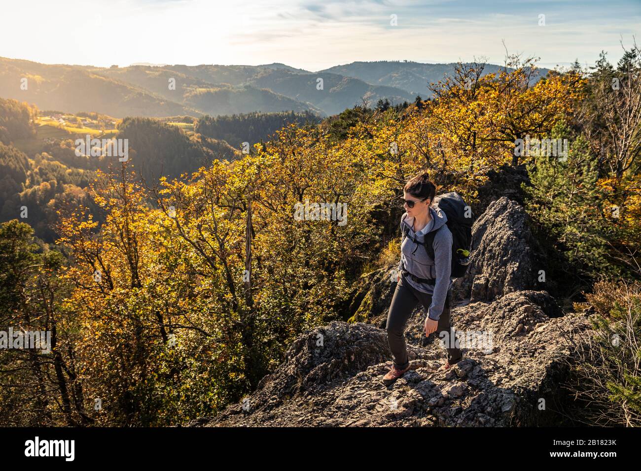 Donna escursioni su sentiero roccioso, Karlruher Grat, Ottenhoefen, Foresta Nera, Germania Foto Stock