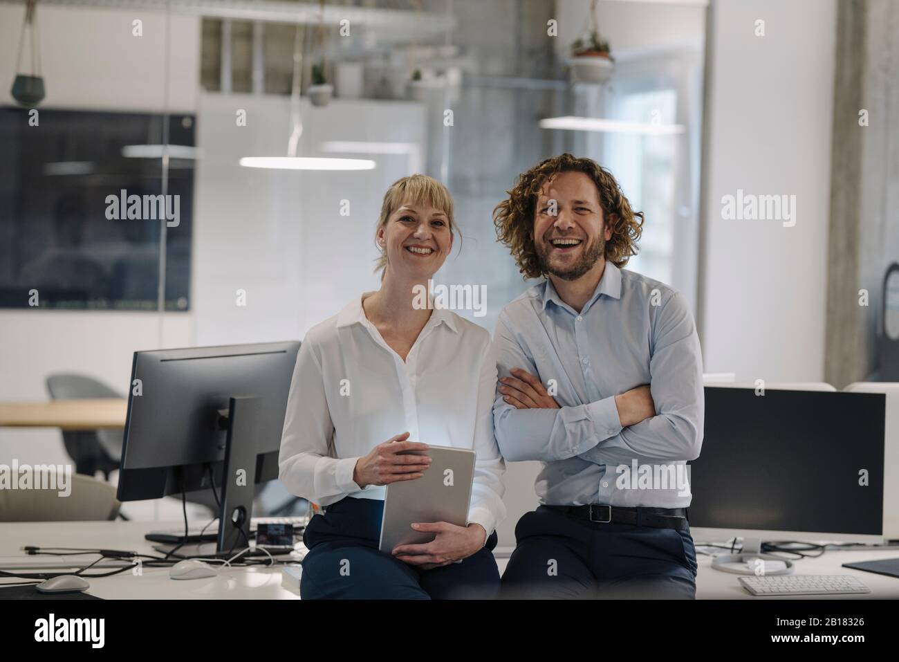 Ritratto di uomo d'affari felice e donna d'affari con tablet in offce Foto Stock