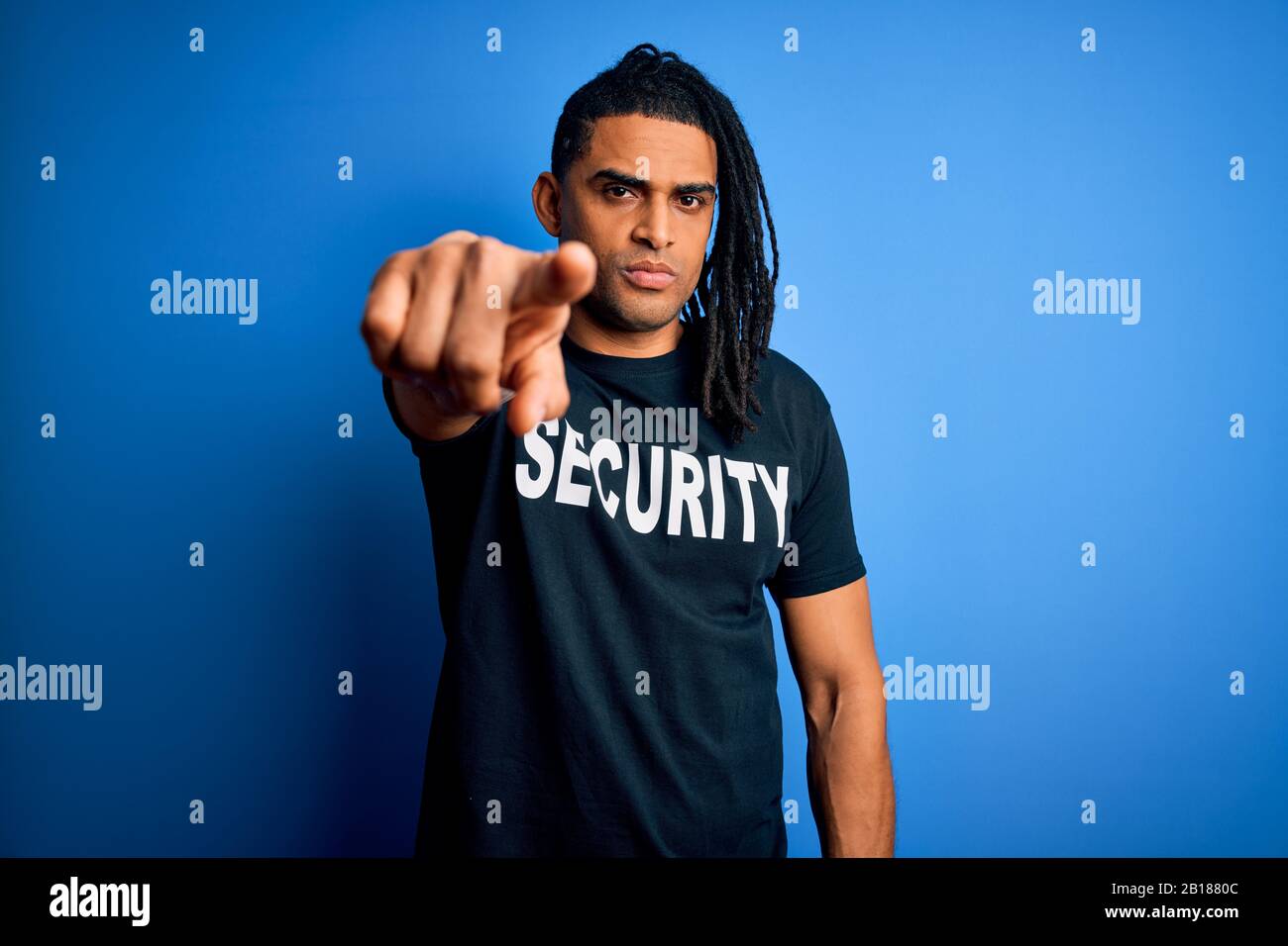 Giovane afro americano protezione uomo con temute serrature indossando uniforme di sicurezza che punta con il dito alla macchina fotografica e a voi, segno della mano, positivo Foto Stock
