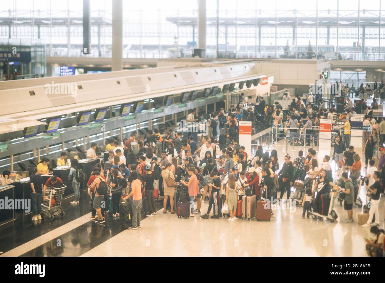 Aeroporto affollato con coda di check-in all'aeroporto di Hong Kong. Foto Stock