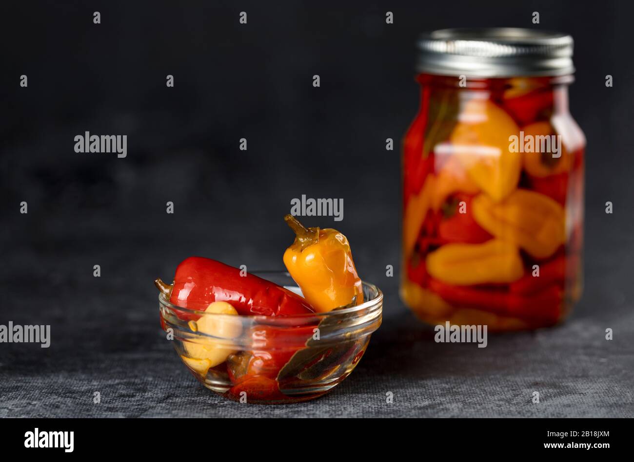 Vasetto di peperoni e spezie in miscela sottaceto cibo Fermentato su sfondo scuro, copia spazio Foto Stock