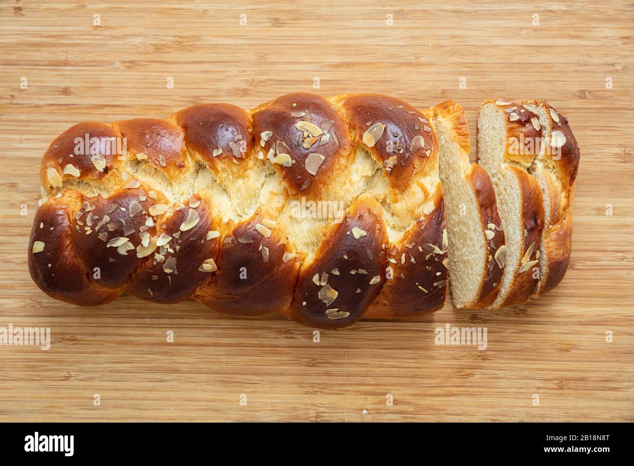 Pane dolce, tsoureki di pasqua coconac affettato su tavola di legno sfondo, vista dall'alto. Brioche intrecciata, festa tradizionale challah Foto Stock