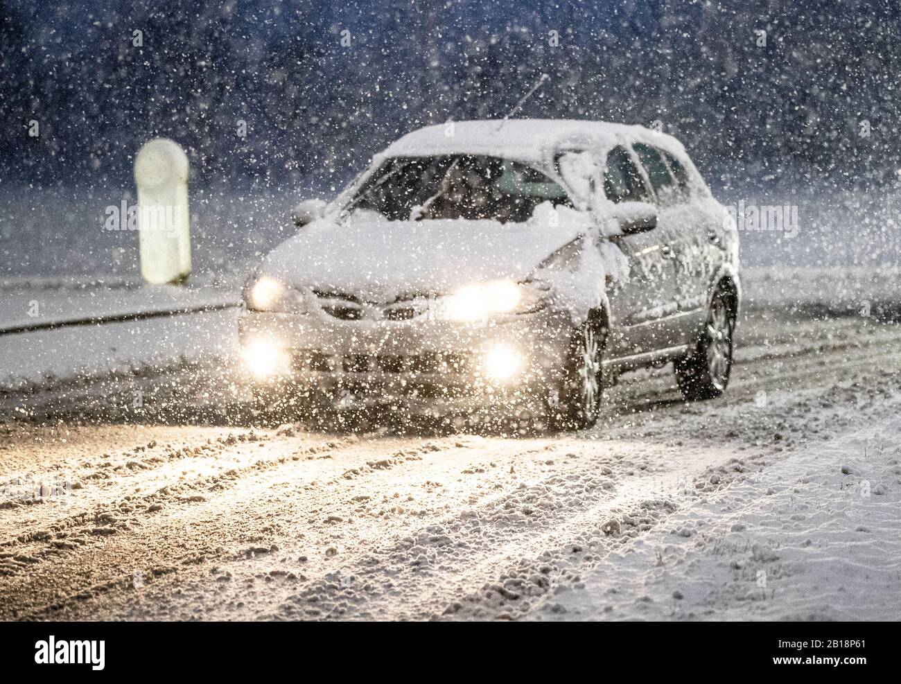 Un'auto viaggia attraverso le condizioni del wintry vicino al Leeming Bar nel North Yorkshire dopo una notte di neve colpita parti del Regno Unito. Foto Stock