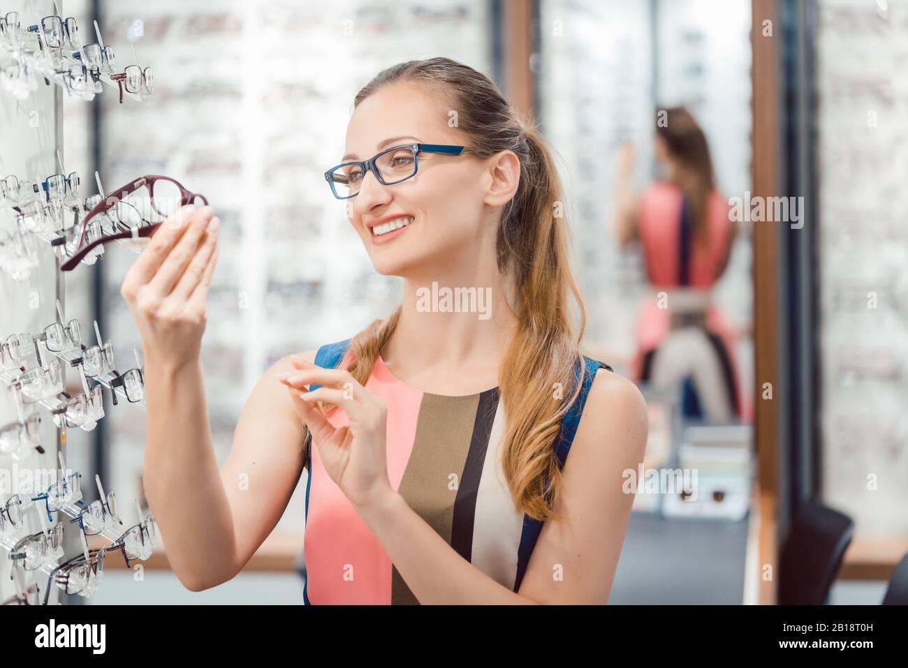Bella donna la scelta di nuovi occhiali in negozio Foto Stock