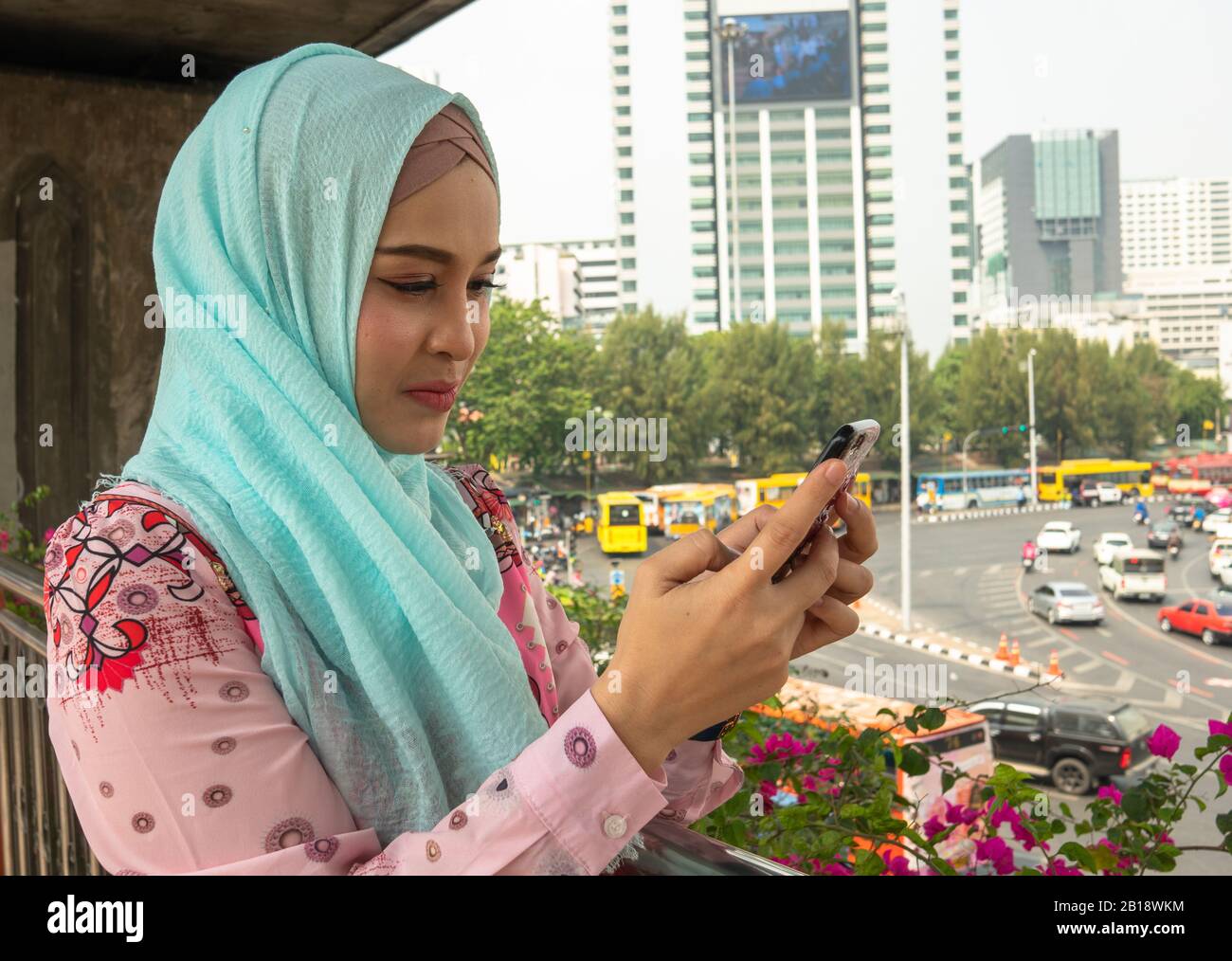 Beautifu ragazze islamiche usano i telefoni mobili mentre aspettano il treno Foto Stock