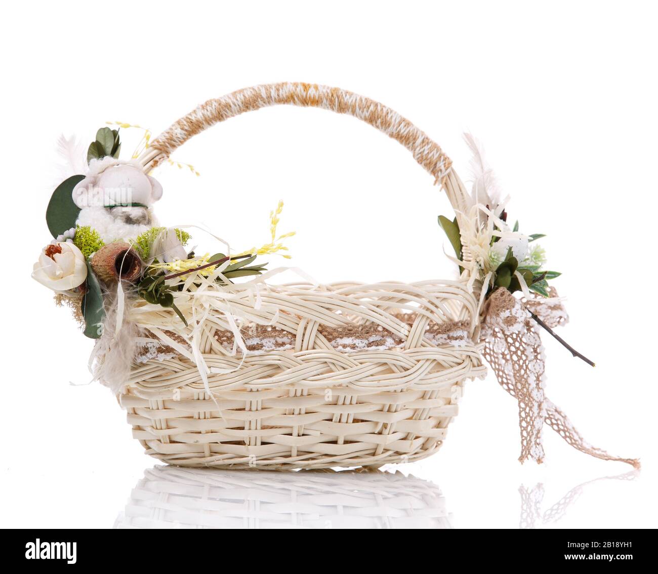 Cesto in vimini naturale con fiori e nastri. Isolato su sfondo bianco. Foto Stock
