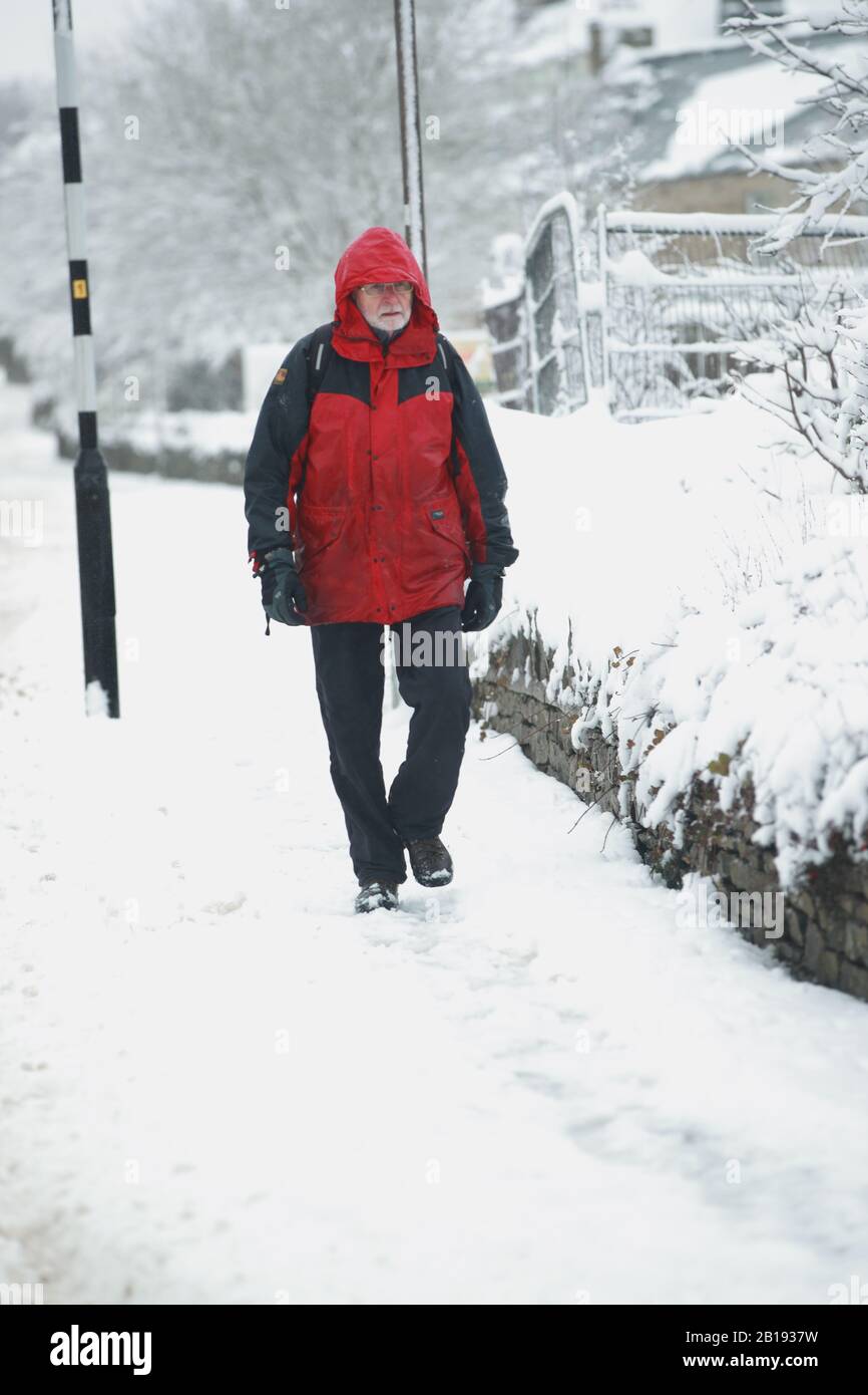 Un uomo cammina attraverso la neve a Leyburn nello Yorkshire Dales dopo la notte neve colpito parti del Regno Unito. Foto Stock