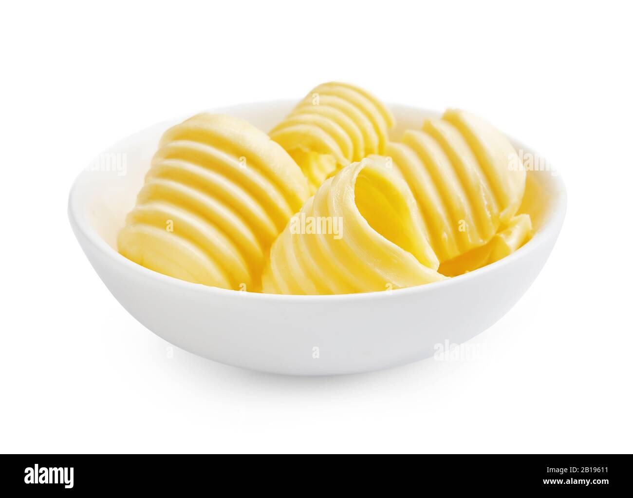 Riccioli di burro o rotoli di burro in recipiente bianco isolato su fondo bianco. Foto Stock