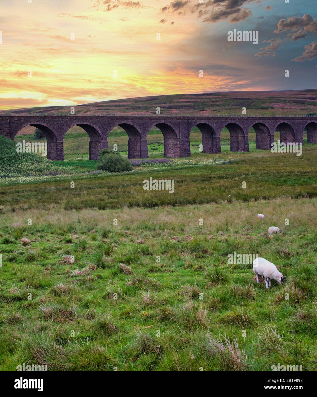 Tramonto sul Viadotto Ribblehead che porta la linea ferroviaria Settle-Carlisle attraverso la Ribble Valley a Ribblehead, North Yorkshire, Inghilterra Foto Stock