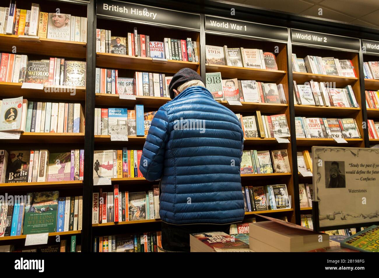 Un cliente che naviga nella sezione Storia in un negozio di libri Waterstones Book Store. Foto Stock