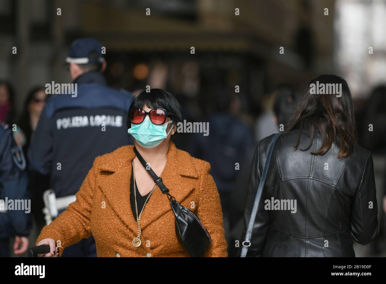 Coronavirus emergenza a Milano, cittadini e turisti passeggiare attraverso il centro della città indossando maschere protettive. Foto Stock