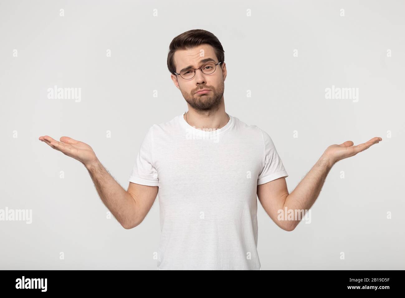 Giovane dubbioso che dimostra spazi vuoti di copia per i prodotti pubblicitari. Foto Stock