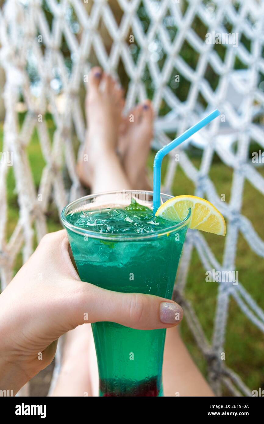 Cocktail rinfrescante in mano femminile, tempo di vacanza Foto Stock