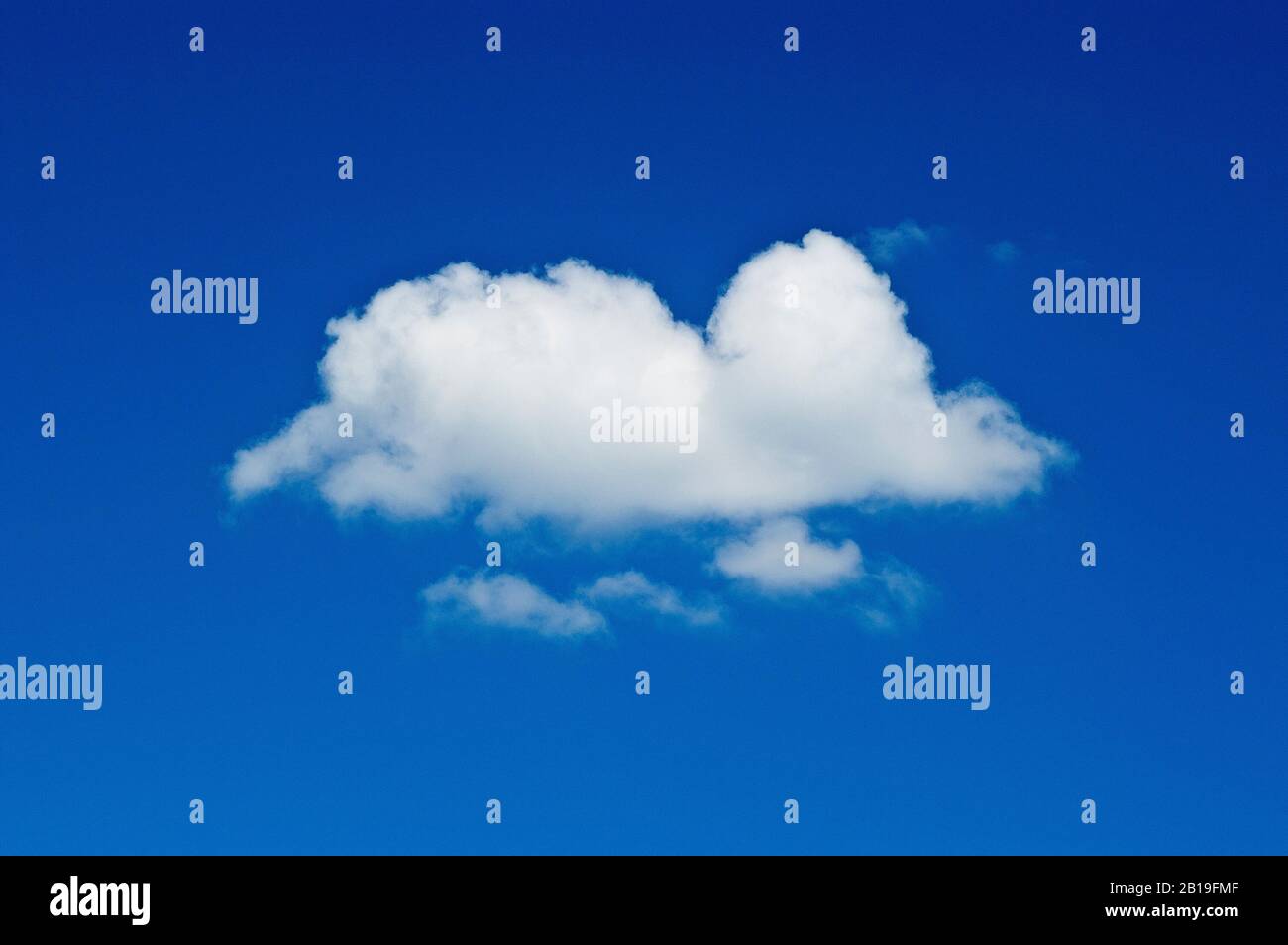 Un singolo fumetto fairweather (cumulus) girato contro un cielo blu pianura. Foto Stock