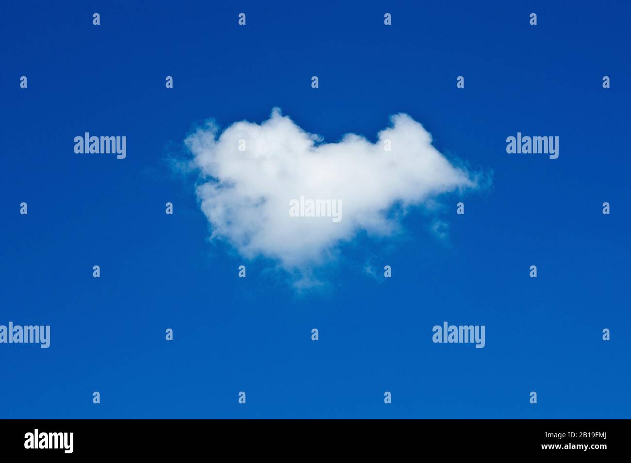 Un singolo fumetto fairweather (cumulus) girato contro un cielo blu pianura. Foto Stock