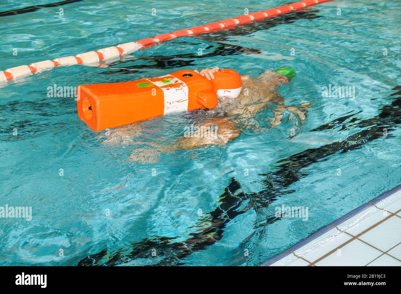 Addestramento bagnino con manichino di salvataggio in una piscina. Foto Stock