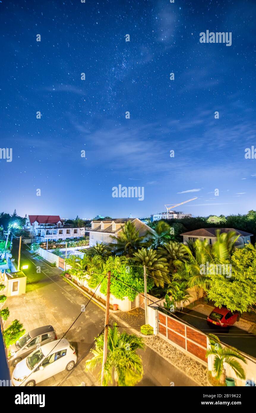 Milky Way a Mauritius. Stelle sopra case e alberi. Foto Stock